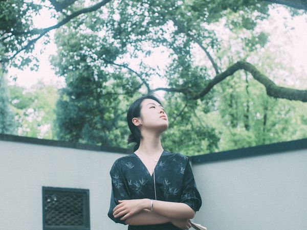 Person meditating peacefully in a calm, natural environment with soft light.